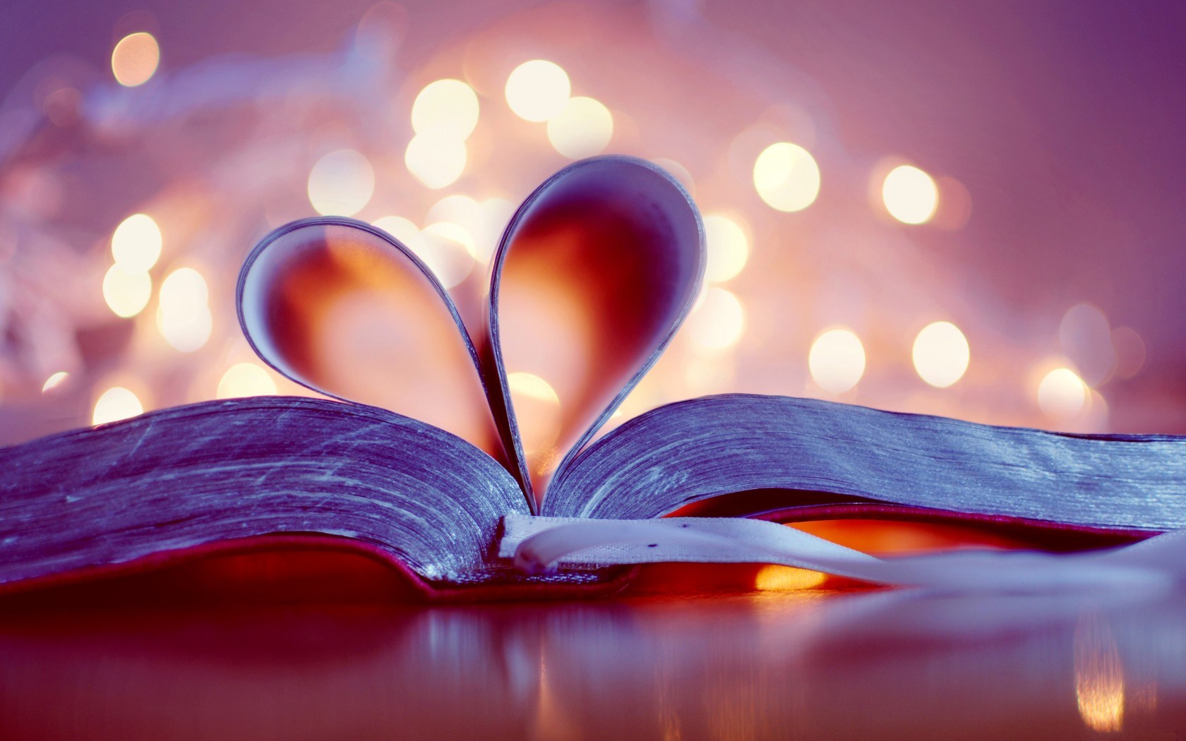 A book open with pages in the middle curved in to form a heart.